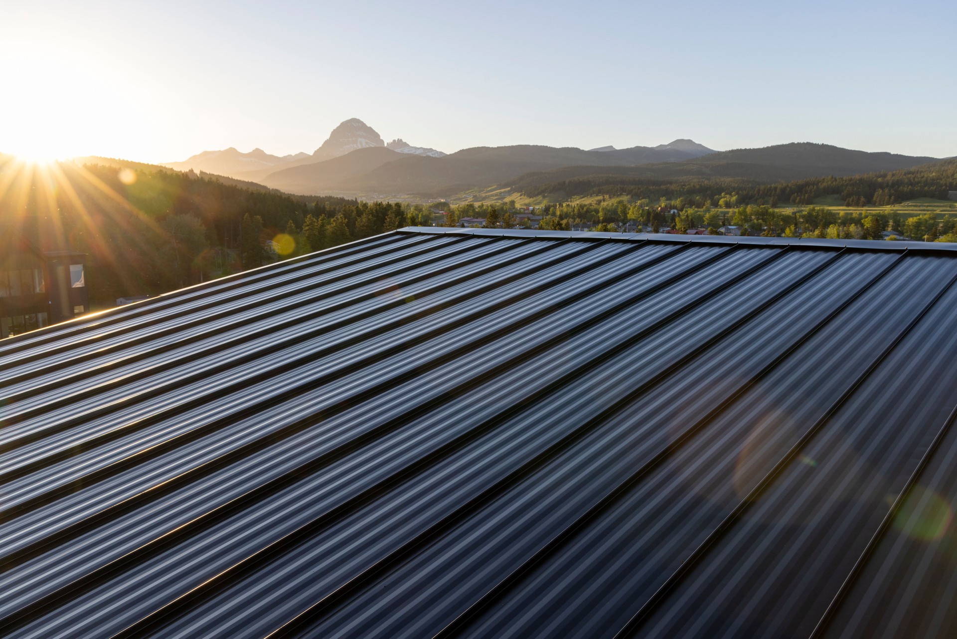 View past metal roof to mountains and sunset